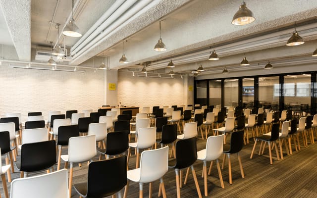 Versatile event space with black and white chairs, perfect for conferences and workshops.
