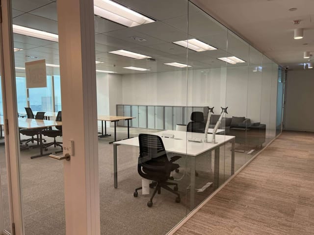 Modern glass-walled meeting room in coworking space, ideal for corporate events and brainstorming.