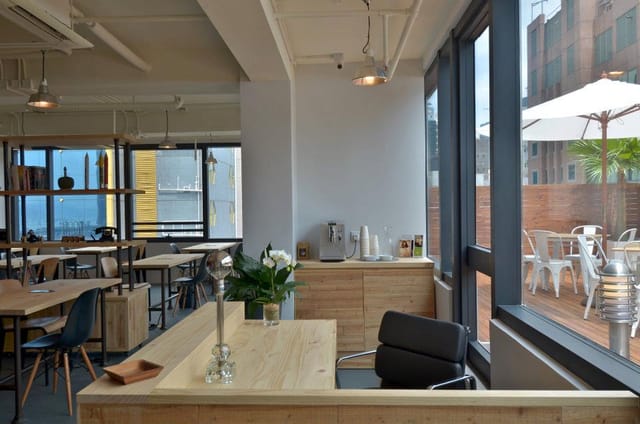 Modern meeting space in The Hive Wan Chai with wooden furniture, ideal for networking events.