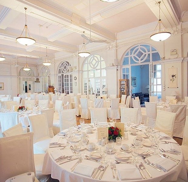 Elegant conference room with round tables, ideal for weddings and corporate events.