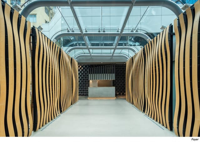 Modern event space with wavy wooden partitions and natural light for gatherings.