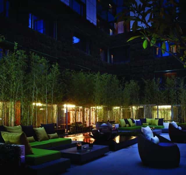Stylish outdoor bar with lush greenery, ideal for networking events and receptions.