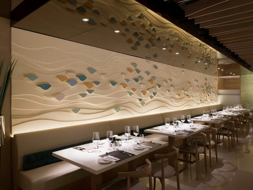 Grand Aqua Suite dining space with wave-patterned wall, ideal for upscale events and gatherings.