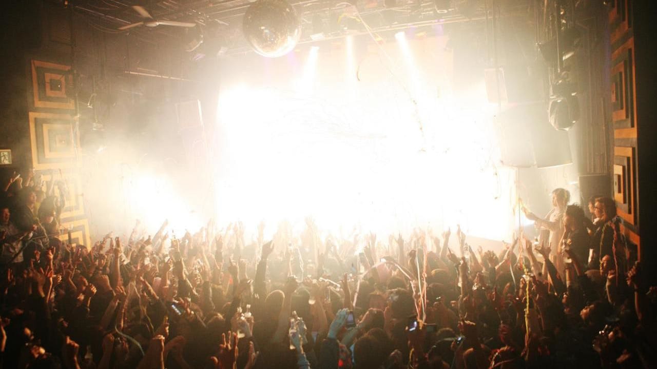 Vibrant nightclub scene at Club Asia with dynamic lighting and energetic crowd celebration.
