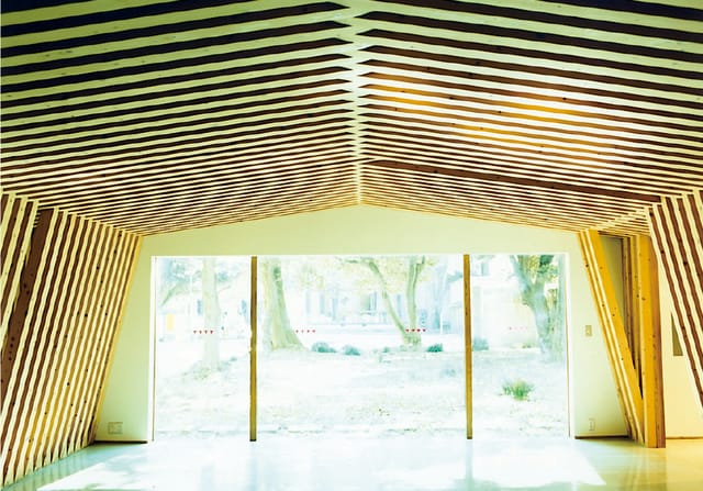 Modern Yayoi Auditorium with wooden beams, ideal for events and meetings.