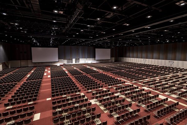 National Convention Hall of Yokohama set for a large conference with empty chairs and screens.
