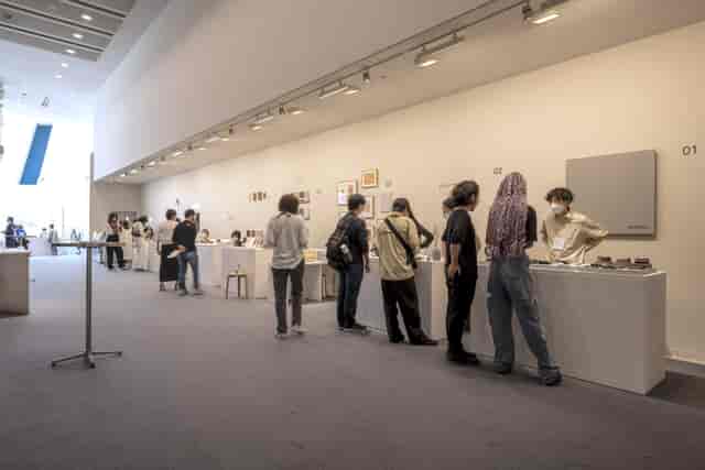 Gallery exhibition with attendees engaging in a well-organized, interactive space.