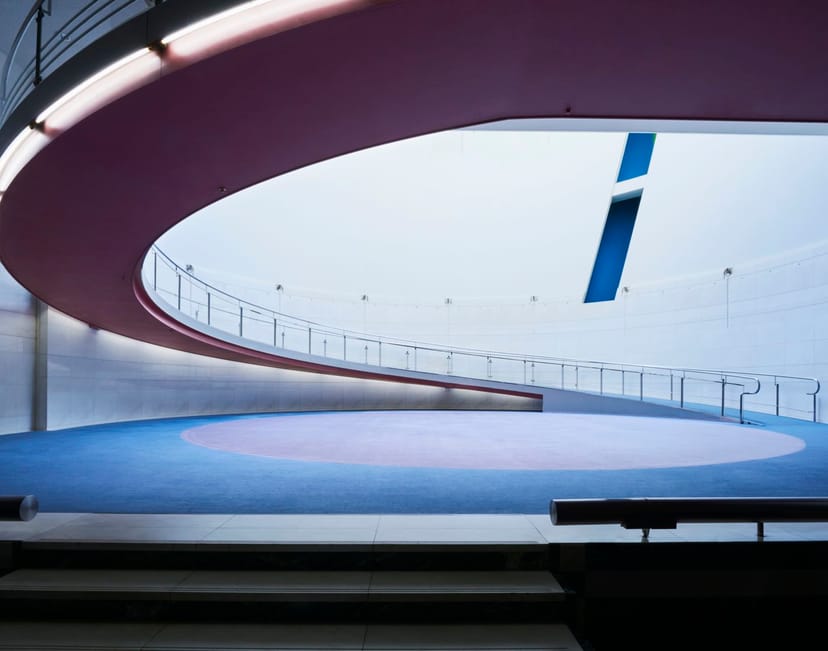 Modern minimalist event space with curved design, ideal for presentations and networking.