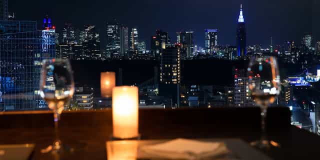 Kaiseki restaurant in Shibuya with elegant table setup and city skyline, ideal for private dinners.