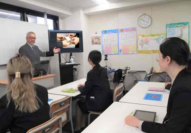 Classroom meeting in Tokyo School of Business with engaged audience and presentation.