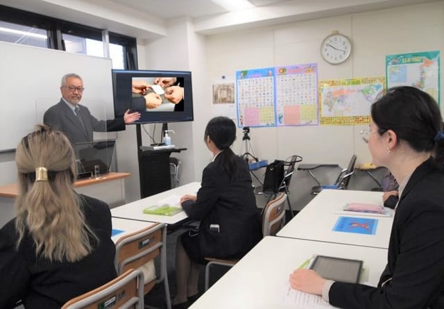 Classroom meeting in Tokyo School of Business with engaged audience and presentation.