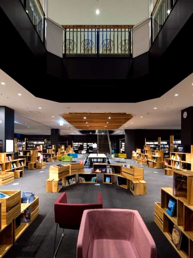 Modern Kōdōkan library with circular wooden bookshelves for workshops and meetings.