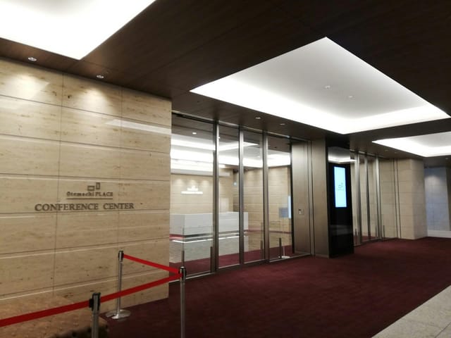 Modern conference hall entrance with polished stone and red carpet for professional events.