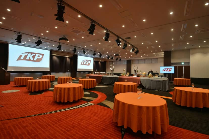 Event space with round tables and screens for networking at TKP Garden City Shinagawa.