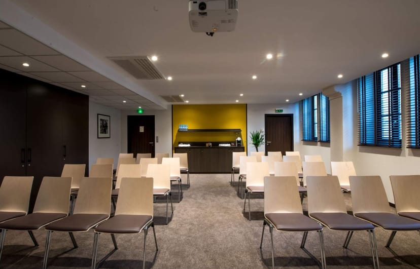 Modern meeting room in Lisbon with projector, ideal for workshops and presentations.