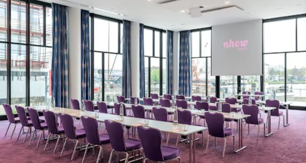 Modern meeting room in Nhow Berlin with purple chairs for corporate events and presentations.