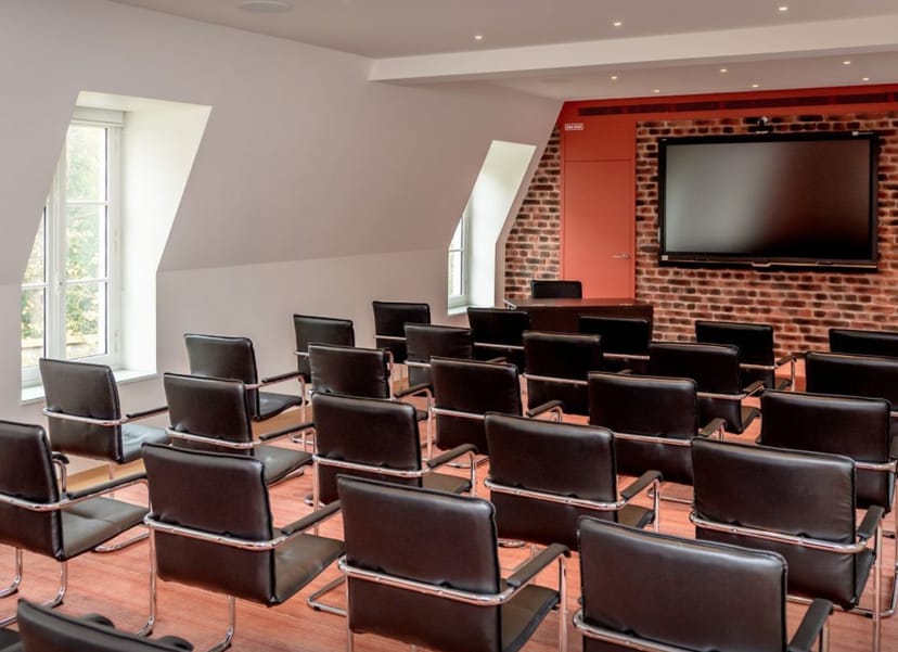 Modern meeting room at Salon Polignac with natural light and brick wall, ideal for events.