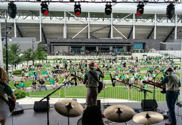 Live Oak Park at Q2 Stadium, vibrant outdoor concert with tiered seating and lush landscaping.