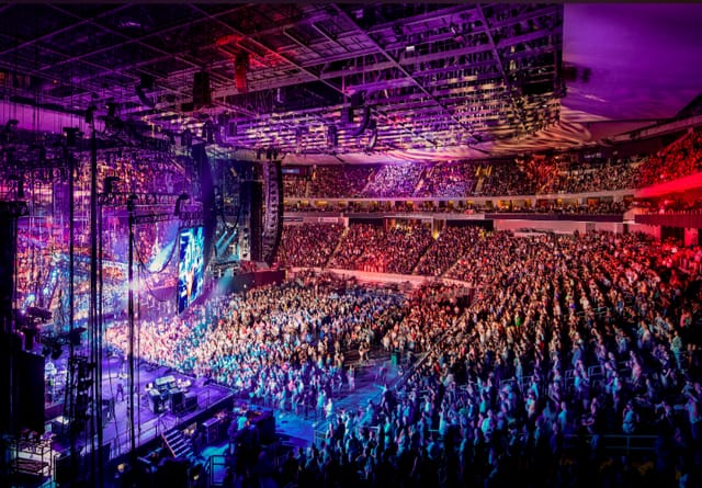 Packed Moody Centre arena with vibrant lighting for immersive events and gatherings.
