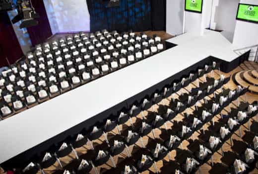 Full venue at Palais Kultubrauerei with central stage, ideal for conferences and presentations.