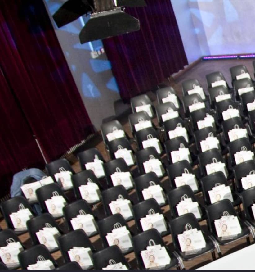 Full venue seating arrangement with gift bags for a professional event at Palais Kultubrauerei.