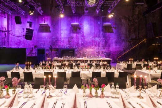 Elegant banquet space with purple lighting for corporate events and dinners.