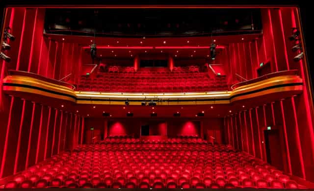 Vibrant red-accented theater with tiered seating for dynamic events and performances.