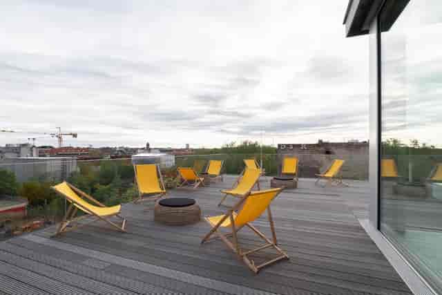 Stylish Soiree Rooftop venue with yellow chairs and fire pit for networking events.