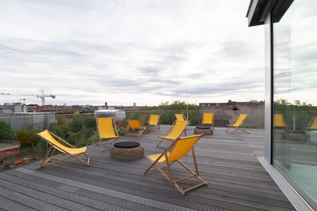 Stylish Soiree Rooftop venue with yellow chairs and fire pit for networking events.