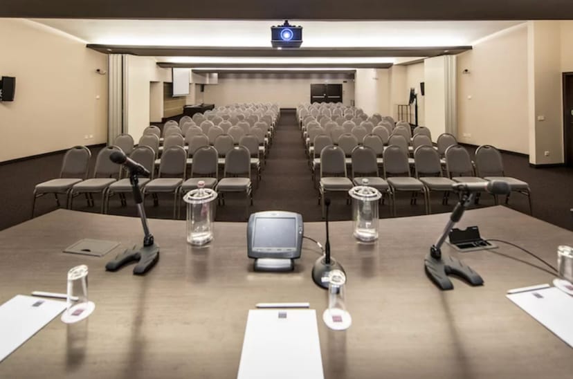 Conference room setup at Aqualux Hotel, featuring arranged chairs for events and presentations.