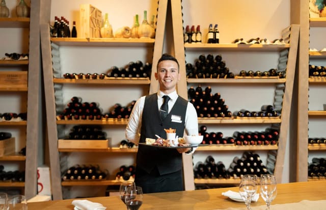 Elegant event space at Aqualux Hotel with a server and wine bottles, perfect for wine tastings.