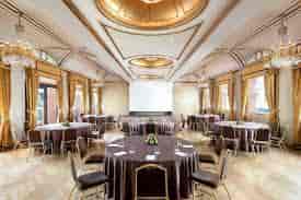 Elegant event space at The Westin Palace Milan with round tables and natural light.
