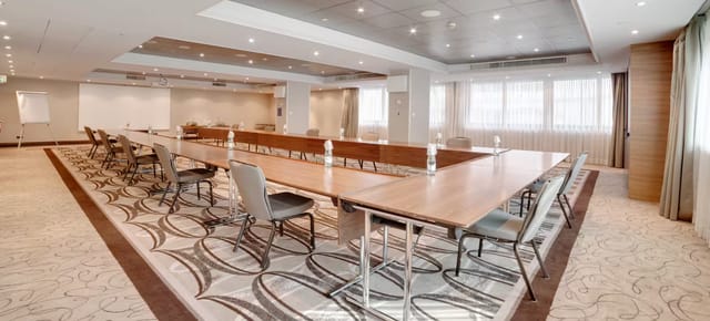 Modern Hilton Milan ballroom with elegant table, ideal for corporate meetings and workshops.