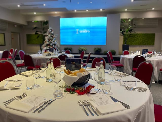 Elegant event space at Ramada Plaza Milano with round tables for corporate gatherings.