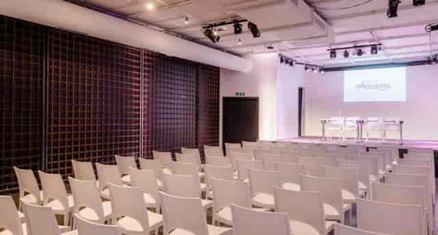Modern lighthouse event space with white chairs for presentations and conferences.