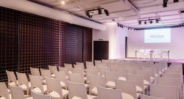 Modern lighthouse event space with white chairs for presentations and conferences.