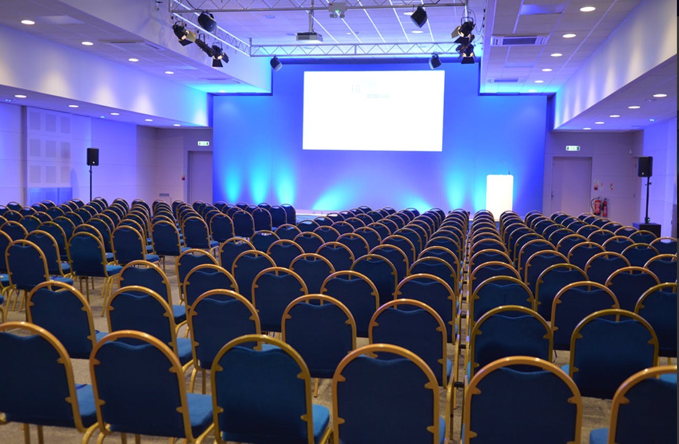 Conference room with blue chairs, ideal for seminars and corporate events at Haynes Motor Museum.