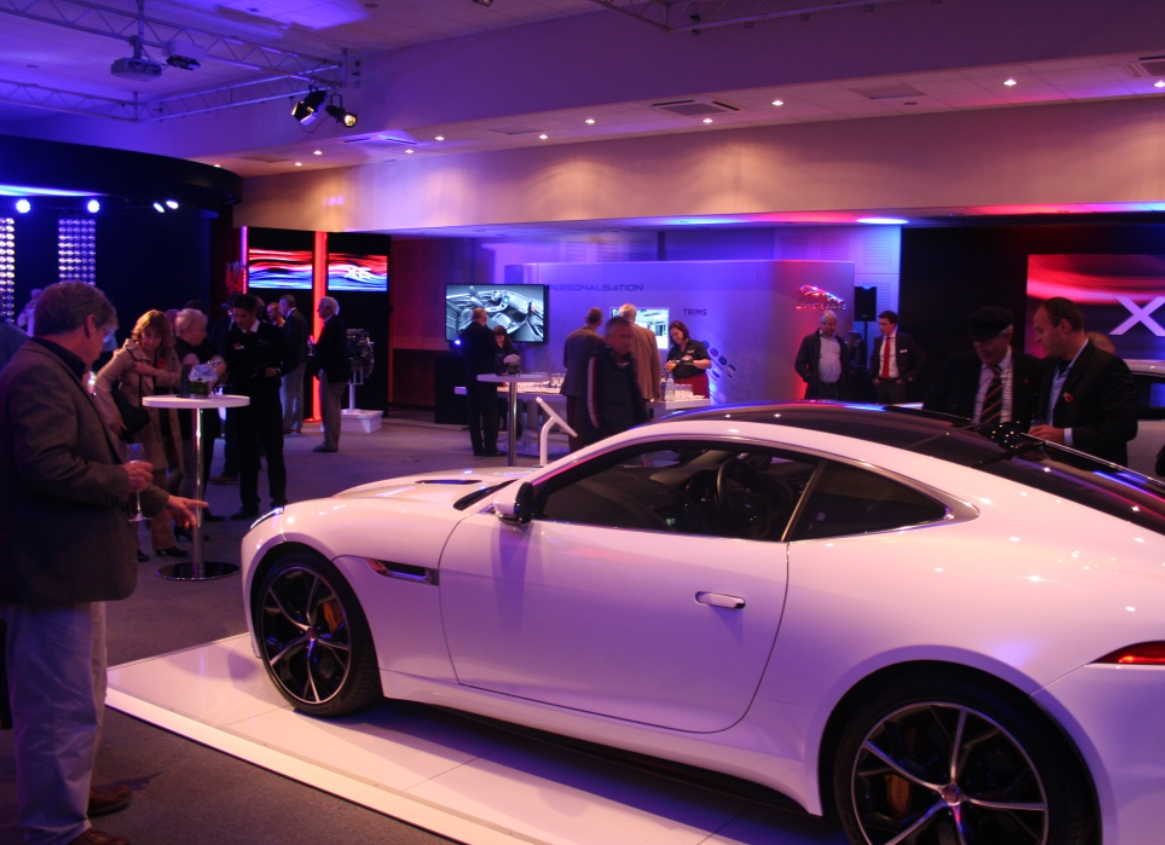 Luxury car centerpiece in upscale Haynes Motor Museum meeting room for automotive events. - Banner