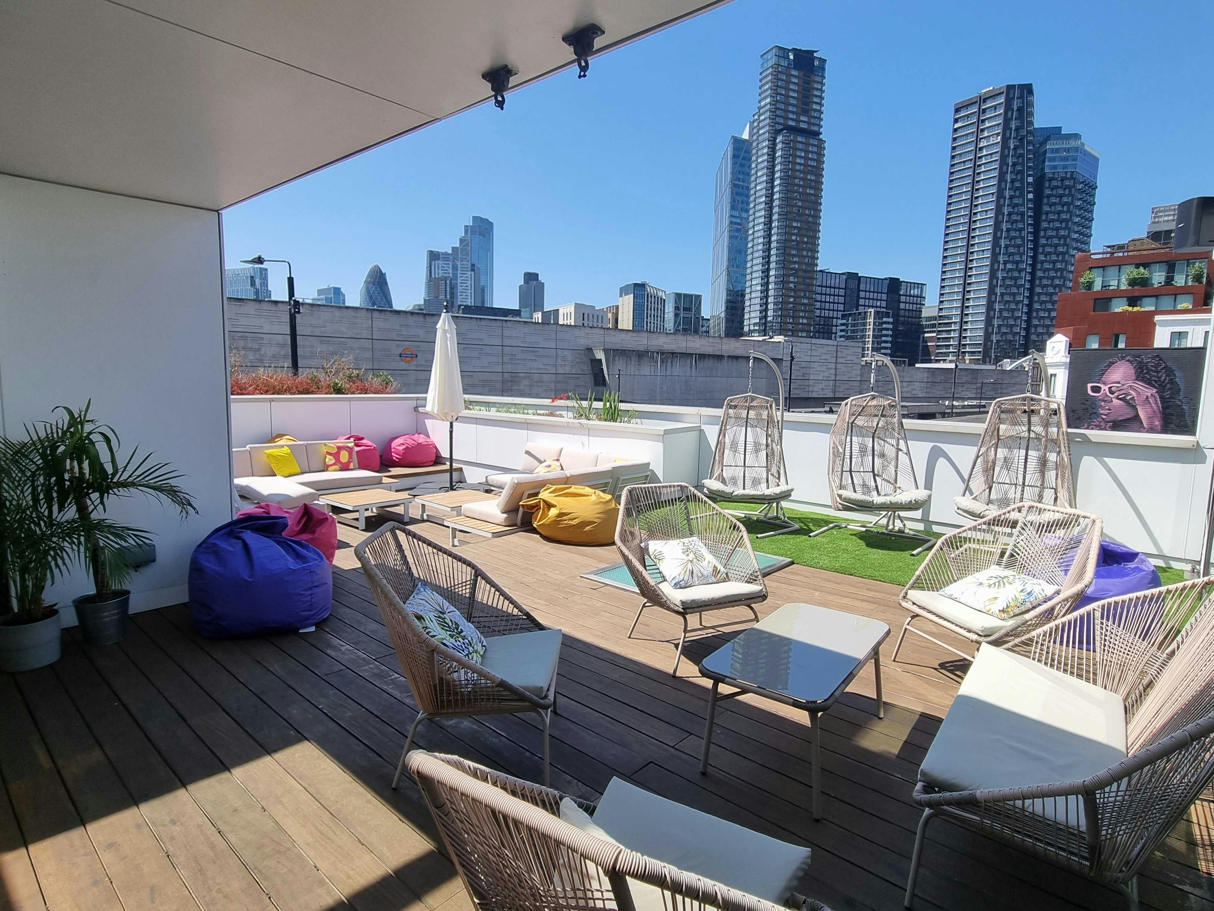 Stylish rooftop event space with hanging chairs, perfect for casual networking and gatherings.