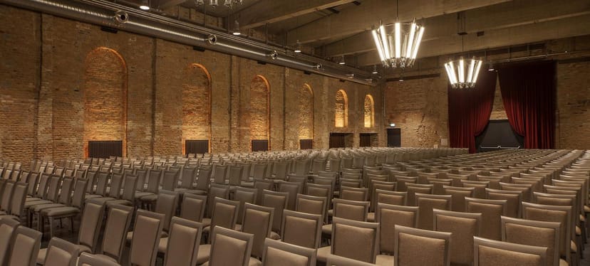 Spacious Bolle Meierei venue with exposed brick, perfect for conferences and presentations.