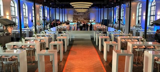Spacious Bolle Meierei venue with high-top tables for networking and cocktail events.