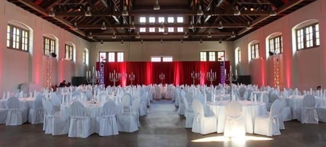 Elegant multi-purpose hall with round tables, ideal for weddings and corporate events.