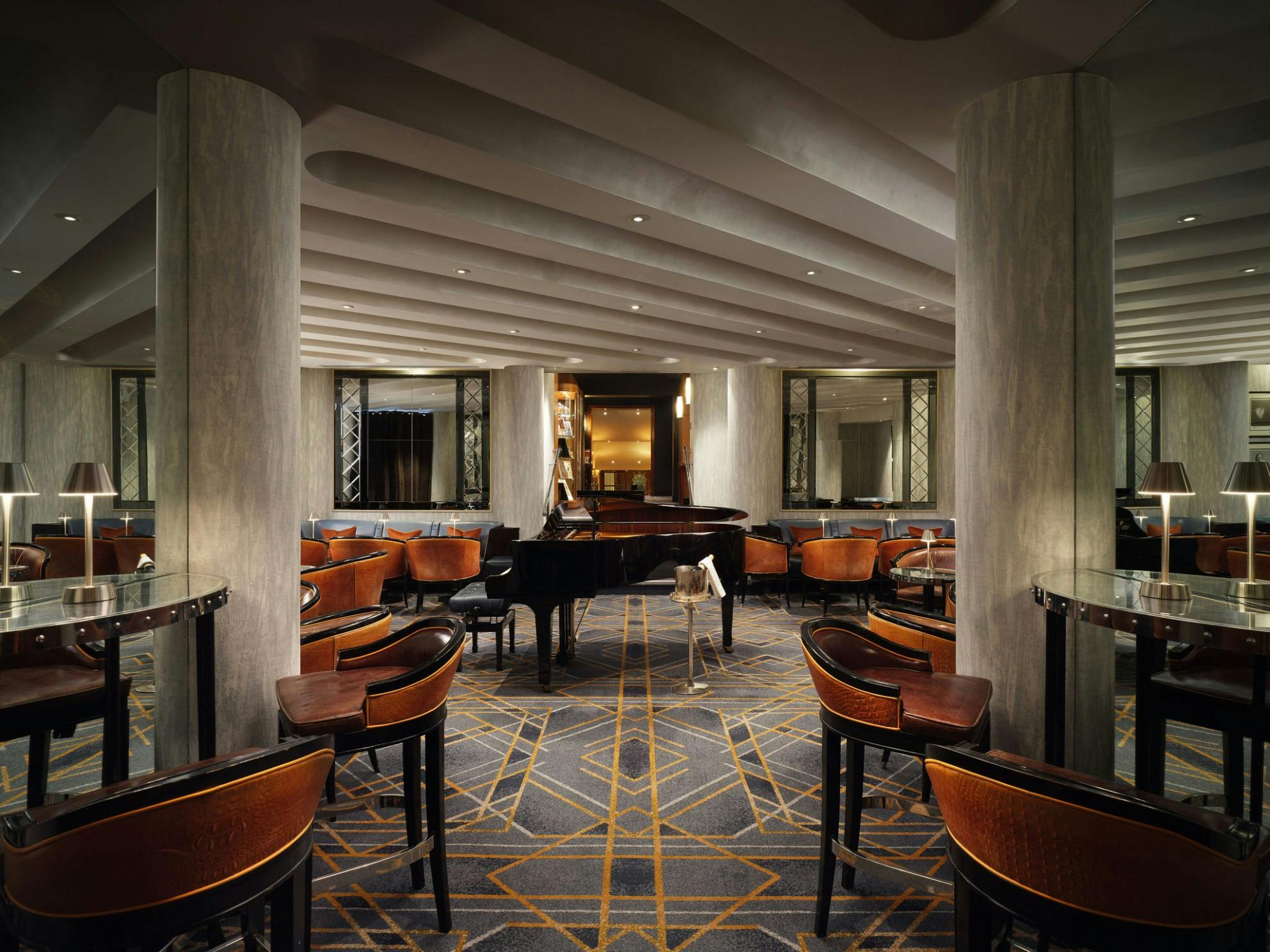 Elegant American Bar at The Savoy, featuring a grand piano for networking events.