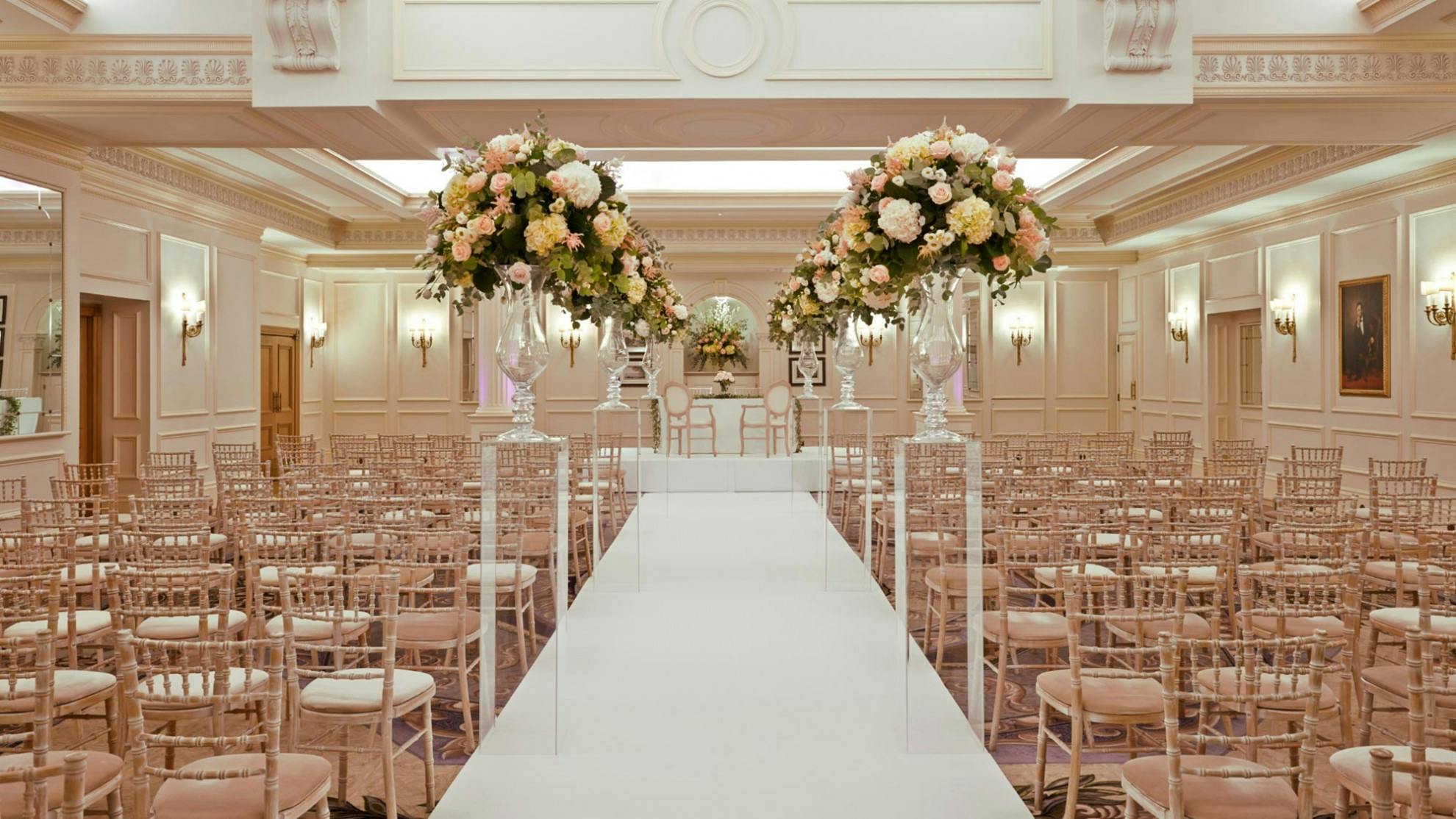 Elegant wedding reception at The Savoy with floral arrangements and gold chiavari chairs.