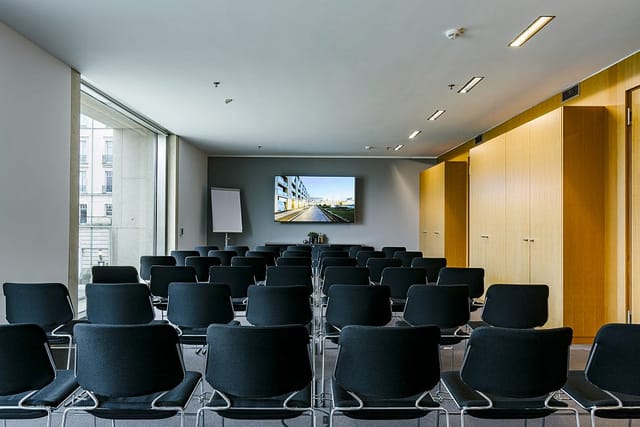 Modern meeting room in AXICA with sleek black chairs for presentations.