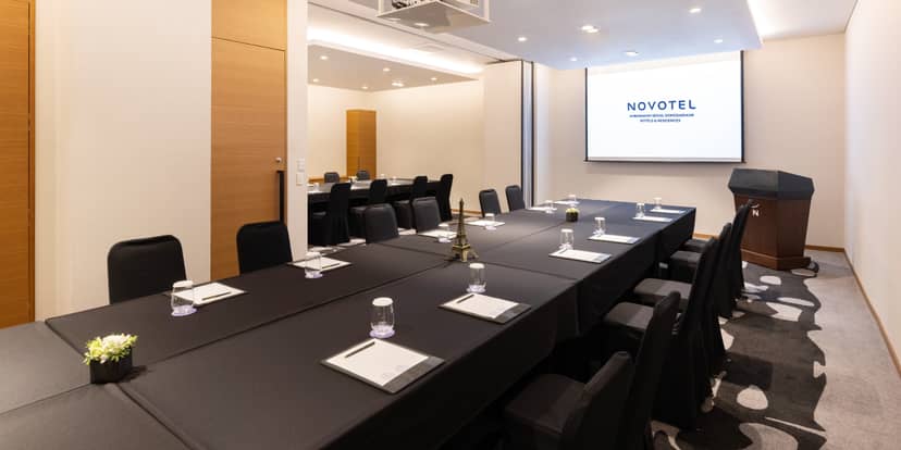 Meeting room with large table and modern decor at Novotel Ambassador Seoul Gangnam.