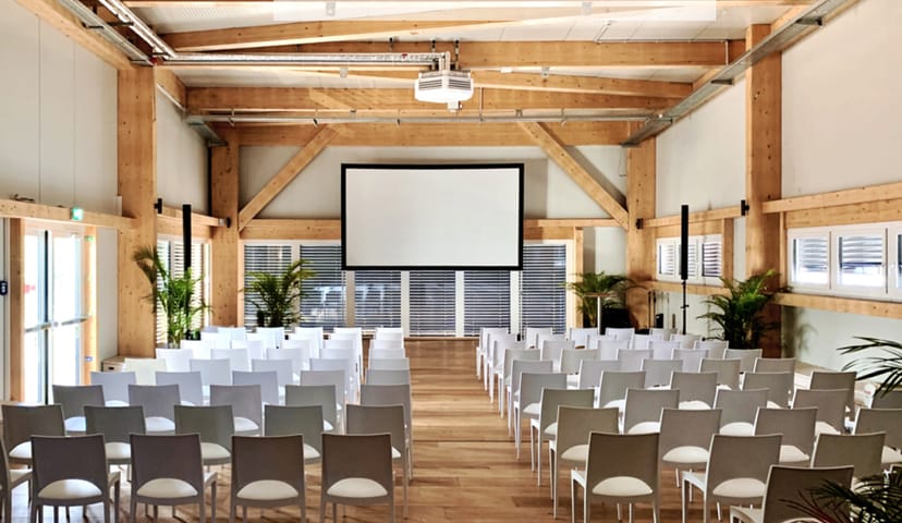 Event space at DAS STRAND LOFT with white chairs and natural light for workshops.