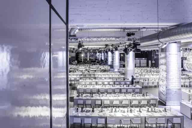 Spacious event venue with elegant tables, perfect for corporate events and formal dinners.