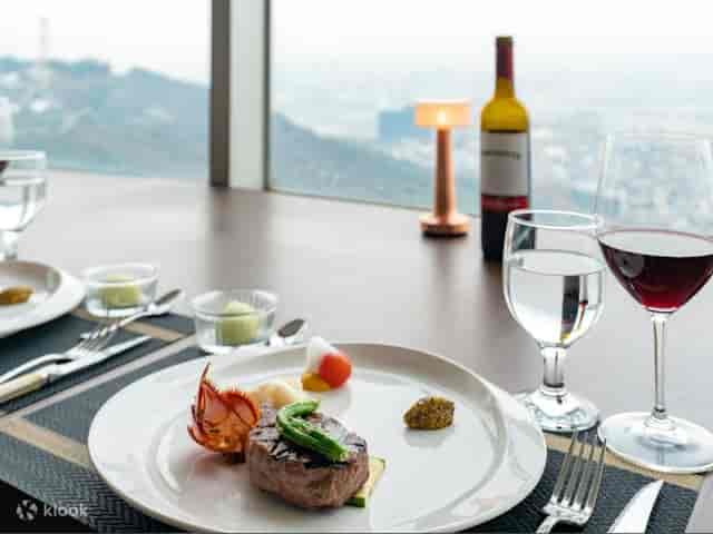 Elegant dining table with gourmet meal at Revolving Restaurant, N Seoul Tower.