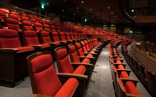 Woori Art Hall auditorium with red seating, ideal for conferences and performances.